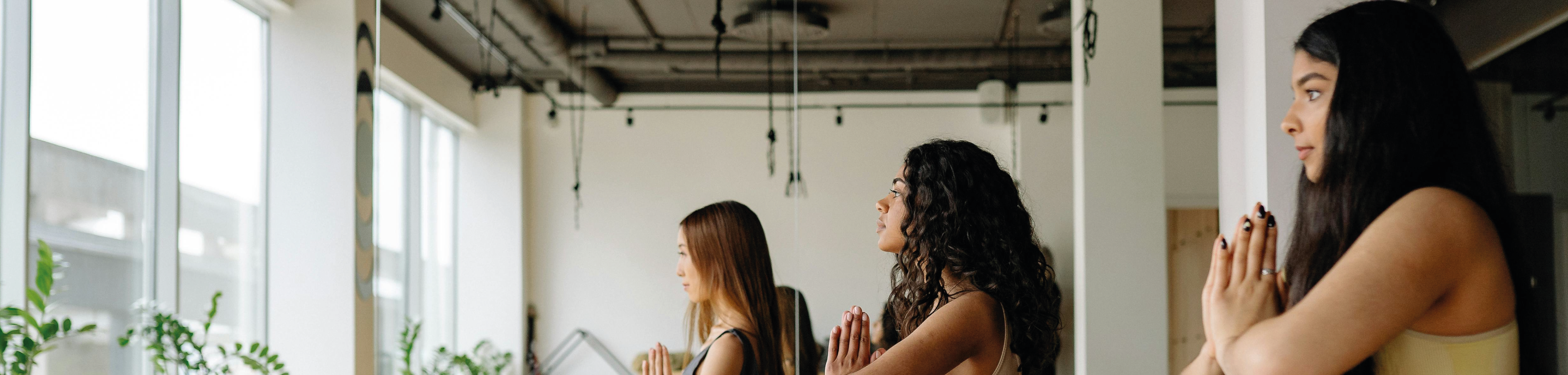 yoga studio mit drei frauen im Schneidersitz